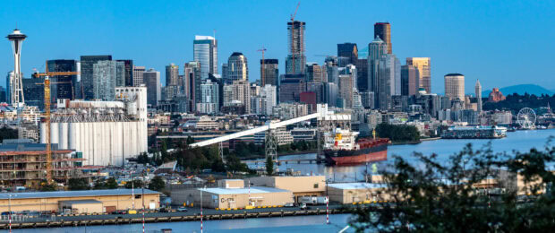 The Seattle skyline features iconic buildings and waterfront views at dusk, 2K Desktop Wallpaper