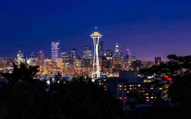 The Seattle skyline is illuminated with lights featuring the Space Needle and city buildings at dusk, 2K Desktop Wallpaper