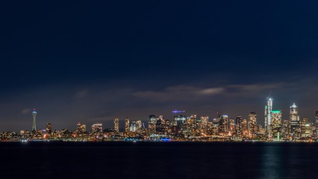 The Seattle skyline shows illuminated buildings and the Space Needle under a dark sky, 4K Desktop Wallpaper