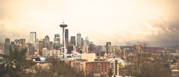 This image shows Seattle skyline with the famous Space Needle under a cloudy sky, HD Desktop Wallpaper
