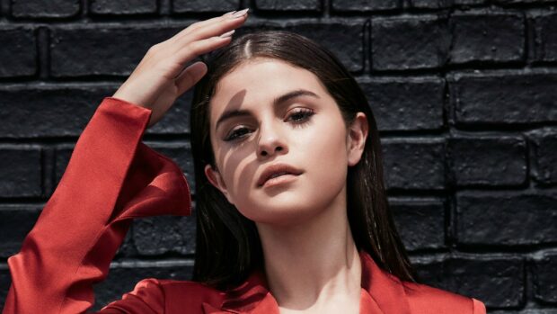 Selena Gomez wallpapers show her with hand near face in front of brick wall, HD Desktop Wallpaper