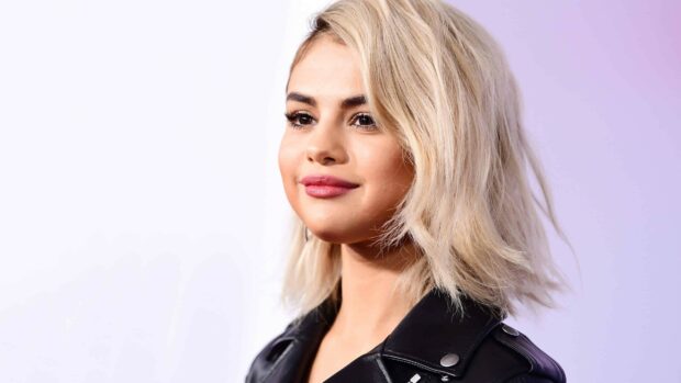 Selena Gomez smiles wearing a black leather jacket at an event, 4K Desktop Wallpaper