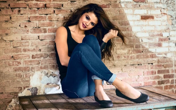 Selena Gomez wallpapers show her relaxed pose and confident smile, 2K Desktop Wallpaper