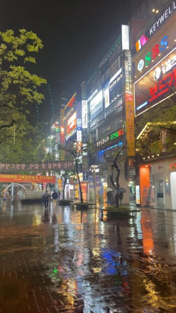 Night street view of Seoul Korea with illuminated signs and wet pavement reflections