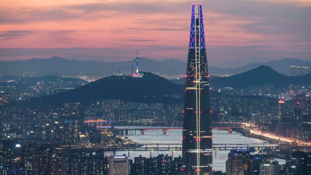 Seoul Korea cityscape with Lotte Tower and mountains at sunset
