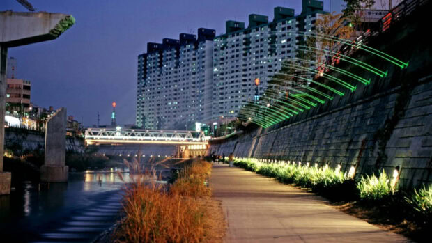 Nighttime cityscape of Seoul Korea with illuminated riverside walkway and apartment buildings