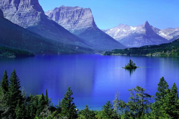A serene mountain lake surrounded by trees and peaks is featured in these Montana Wallpapers, 2K Desktop Wallpaper