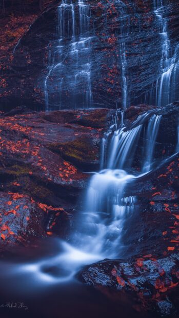 A peaceful waterfall flowing through rocky Vermont landscape with autumn leaves, 2K Mobile Wallpaper