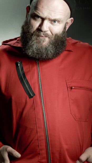 A bearded man wearing a red jumpsuit stares intensely in Money Heist Wallpapers, 4K Phone Wallpaper