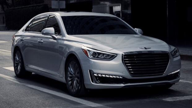 A silver Genesis car is parked on a quiet urban street with reflections on its surface, 2K Desktop Wallpaper