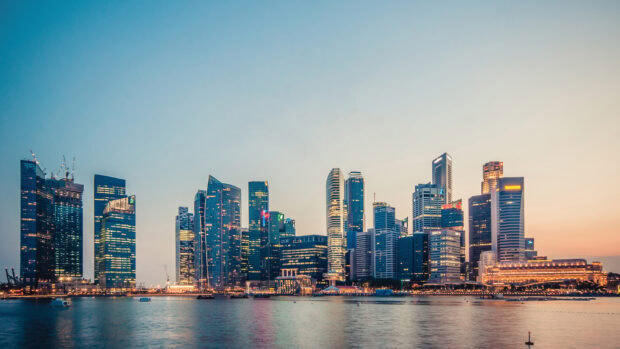 Modern Singapore skyline at dusk with illuminated skyscrapers and calm waterfront