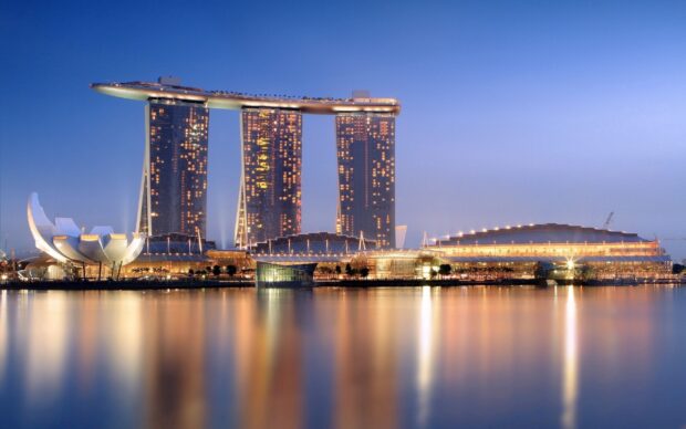 The Singapore skyline features iconic architecture reflecting on calm waters at dusk