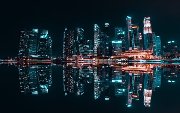 The Singapore skyline with illuminated skyscrapers reflected in calm water at night showcasing the vibrant cityscape