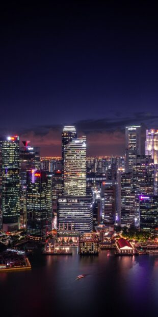 Night view of Singapore cityscape with vibrant lights and modern skyscrapers reflecting on the water