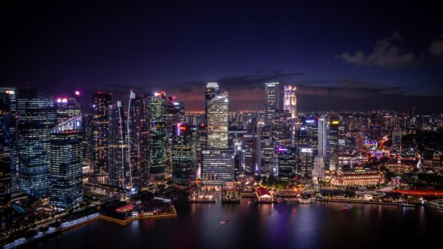 The Singapore skyline illuminated at night with vibrant city lights and high rise buildings