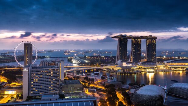 Evening cityscape featuring Singapore skyline with iconic Marina Bay Sands and Singapore Flyer