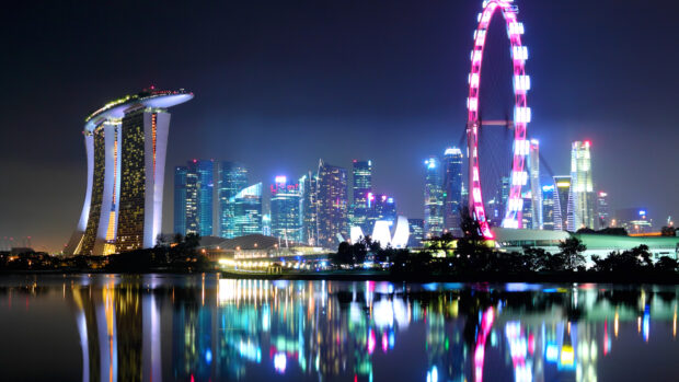Nighttime view of Singapore Skyline with illuminated buildings and reflections on the water