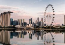 The Singapore skyline with Marina Bay Sands and the giant Ferris wheel reflected in calm water