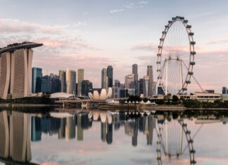 The Singapore skyline with Marina Bay Sands and the giant Ferris wheel reflected in calm water