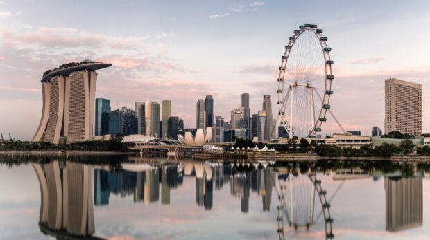 The Singapore skyline with Marina Bay Sands and the giant Ferris wheel reflected in calm water
