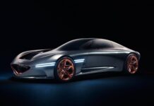 A sleek Genesis car with futuristic lines and copper wheels is showcased in a dark setting, 4K Desktop Wallpaper