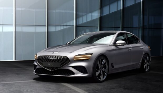 A silver Genesis car is parked in front of a modern glass building showcasing its elegant design, HD Desktop Wallpaper