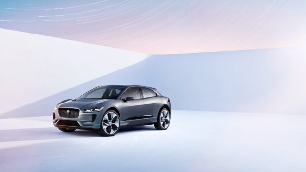 A sleek Jaguar I Pace electric car is displayed in a minimalist white space with soft lighting, 4K Desktop Wallpaper