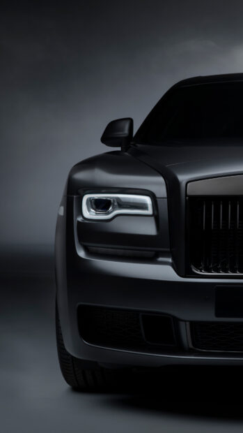 The Rolls Royce Ghost shows a sleek front design with illuminated headlights, 4K Mobile Wallpaper