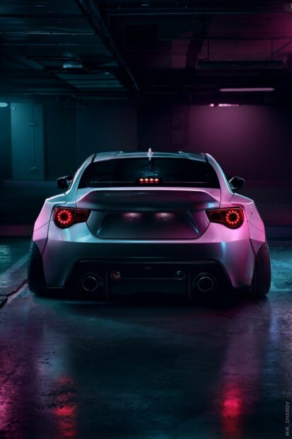 Sports car in a dimly lit parking garage with neon lighting.