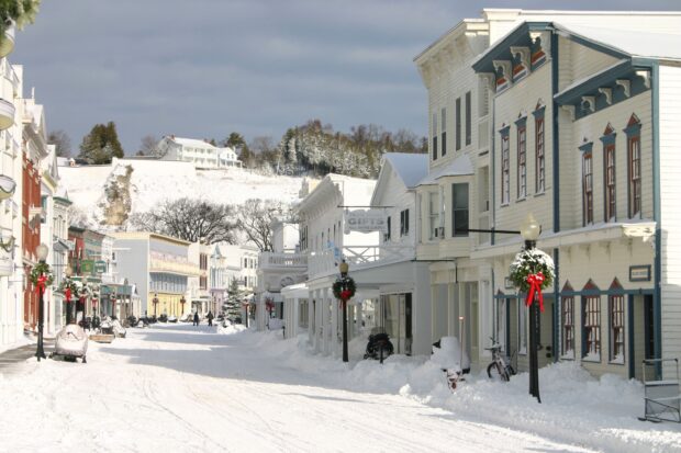 The snow covered street shows old buildings and holiday decorations in Mackinac Island, 2K Desktop Wallpaper