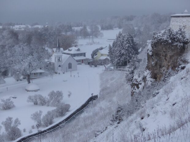 A scenic view of Mackinac Island covered in snow with trees and buildings, HD Desktop Wallpaper
