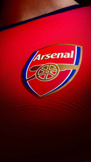 Close up of soccer jersey with Arsenal logo and soccer emblem on red fabric
