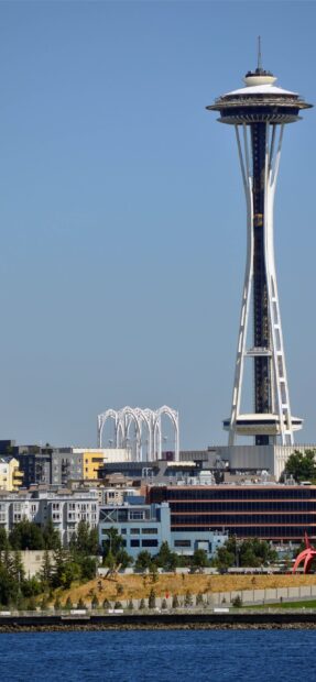 A clear view of Space Needle surrounded by city buildings on a sunny day