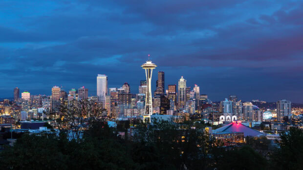A stunning view of the Space Needle in Seattle during twilight with city lights illuminating the skyline