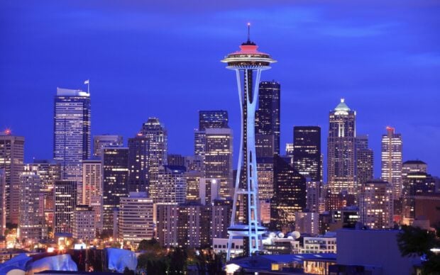 The Seattle skyline featuring the iconic Space Needle at dusk with city lights illuminating the scene