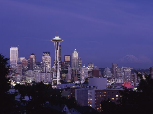 The Seattle skyline featuring the Space Needle at dusk with Mount Rainier in the background