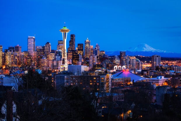 A stunning view of Seattle skyline with the Space Needle and Mount Rainier in the background at dusk
