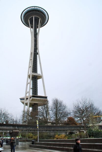 The Space Needle structure stands tall above the cityscape with leafless trees around