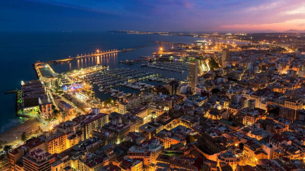 The Spain cityscape with harbor shines brightly at dusk under the colorful sky, 2K Desktop Wallpaper