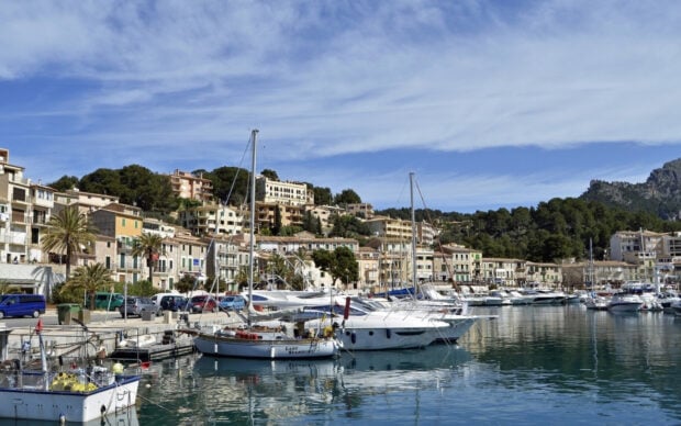 A Spanish coastal town with boats docked by the waterfront under a clear sky features Spain Wallpapers,
