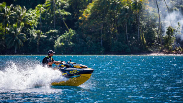 A man riding a yellow jet ski creating a splash on a blue lake near forest, 4K Desktop Wallpaper