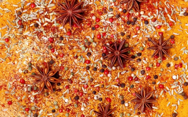 Star anise and mixed spices spread on a vibrant seasoning powder surface