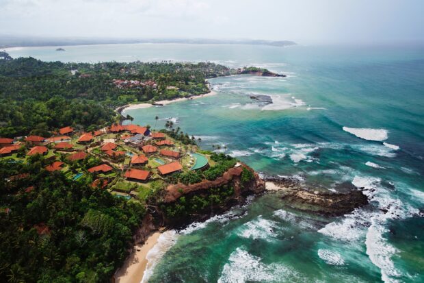 A coastal area in Sri Lanka shows green vegetation and orange rooftops, 2K Desktop Wallpaper