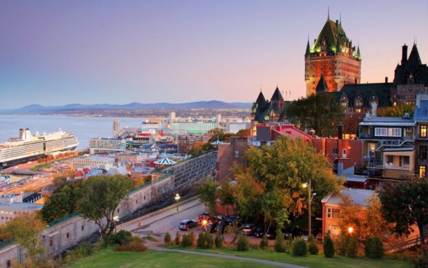Stunning view of the St Lawrence River with historic buildings and a cruise ship at sunset
