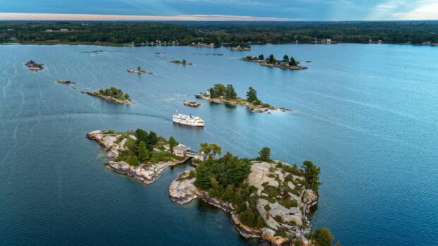 A scenic view of the St Lawrence River with small islands and a boat cruising on the water