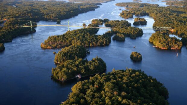 Aerial view of St Lawrence River with lush green islands and connecting bridges under sunlight