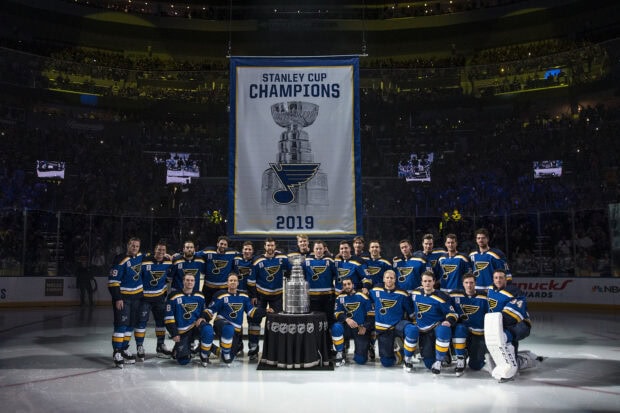 The St Louis Blues team poses with the Stanley Cup Champions banner in 2019, 2K Desktop Wallpaper