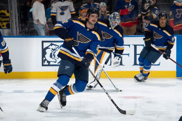 A St Louis Blues player skillfully controls the puck during a game with teammates nearby, 2K Desktop Wallpaper