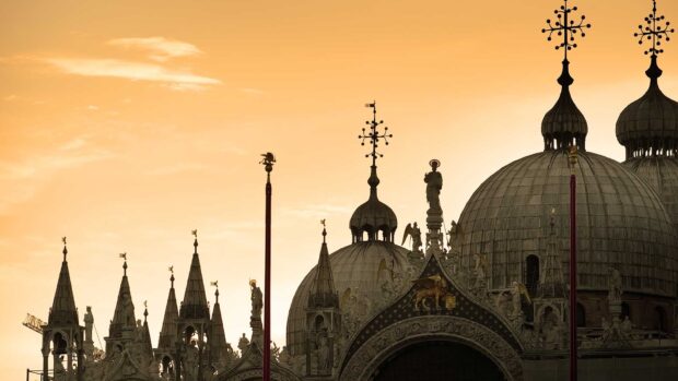 The silhouette of St Marks Basilica is seen against a warm orange sunset sky, HD Desktop Wallpaper