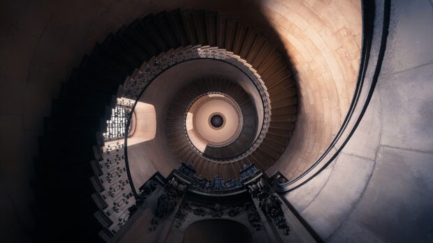 A spiral staircase with intricate iron railings viewed from below